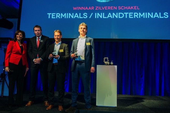 Niels Dekker van RWG (2e van rechts) en Jouke Schaap van APMT (rechts) Maasvlakte 2 met hun prijs. Links presentatrice Astrid Joosten, naast haar  